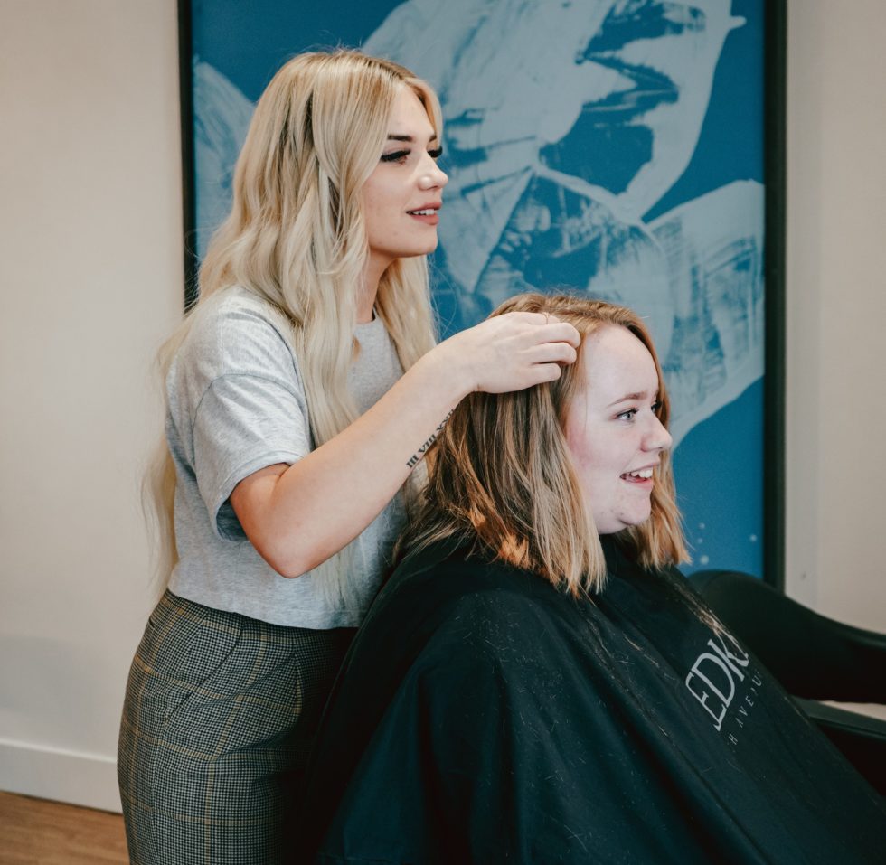 Woman styling another womans hair