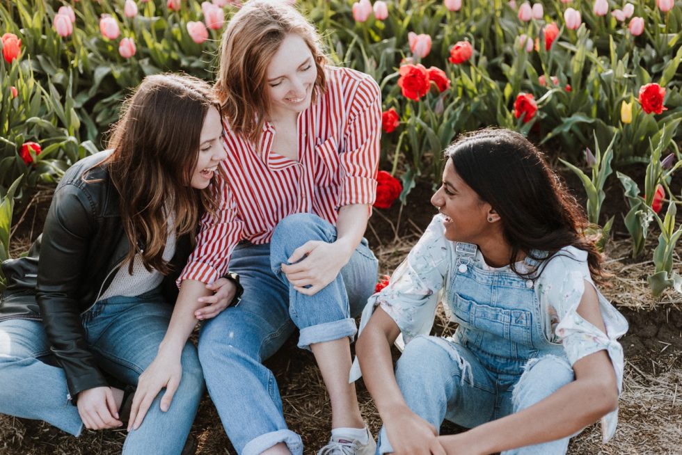 Women sitting by flowers laughing