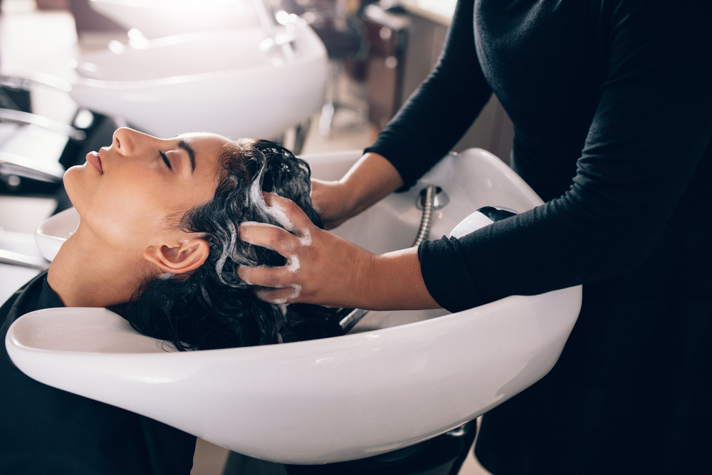 cosmetologist washing hair