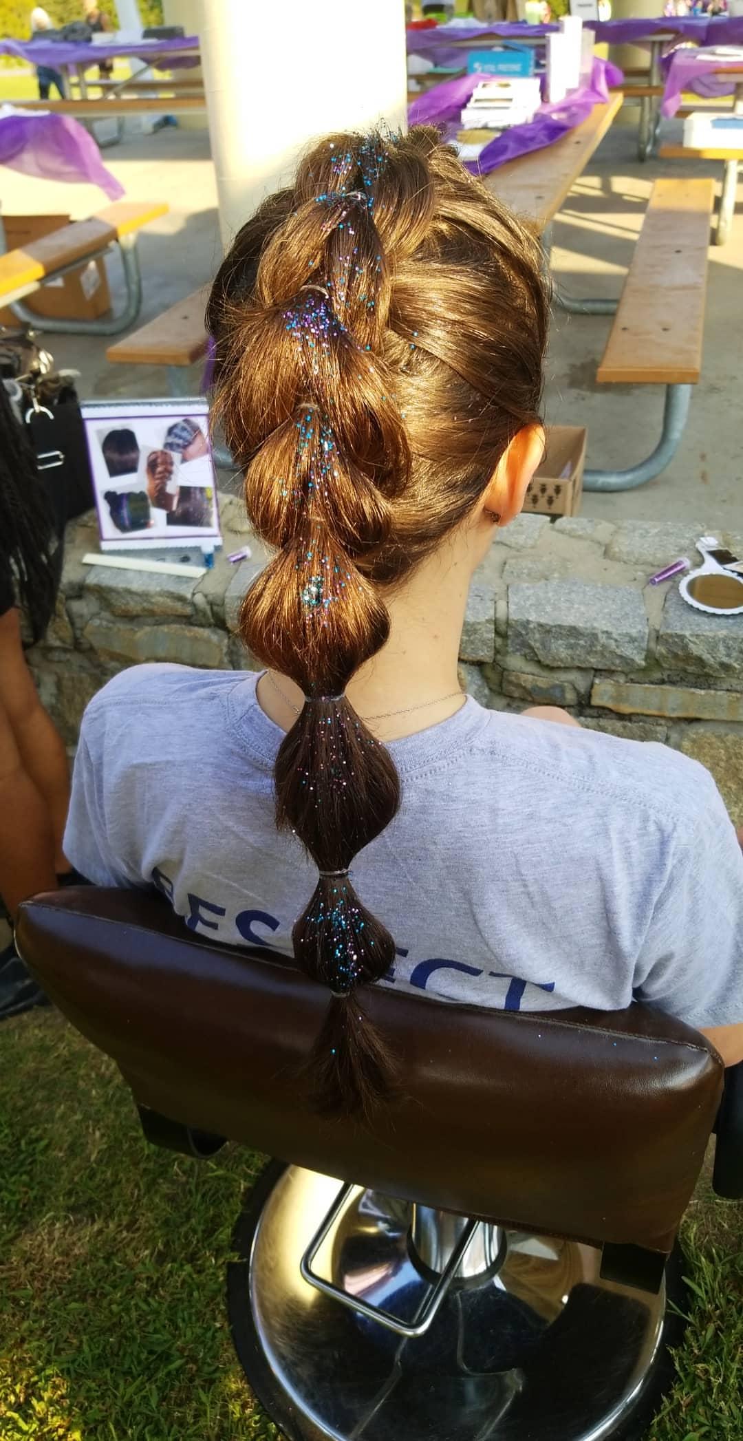 Back of a girls head with glitter in her braid