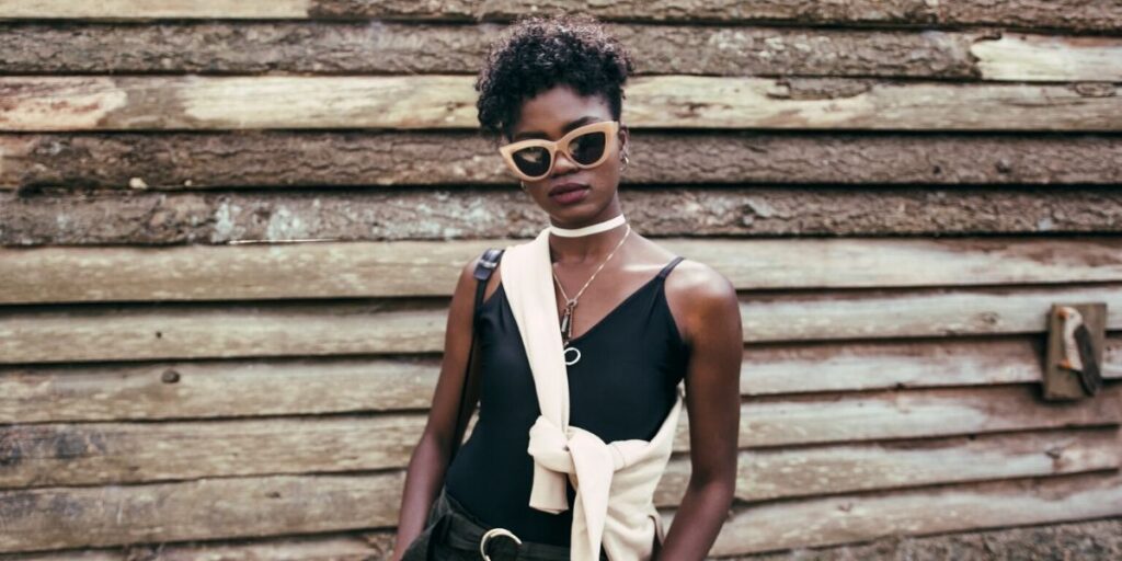 fashionable woman standing in front of a wood wall