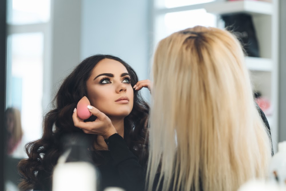 Woman doing another woman's makeup