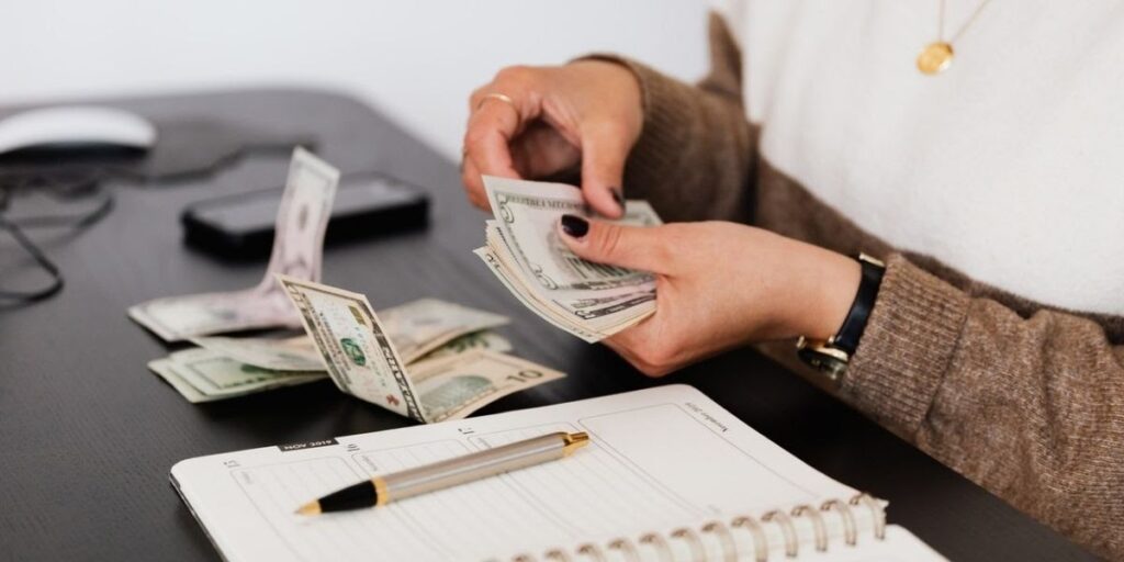 woman counting money with a planner