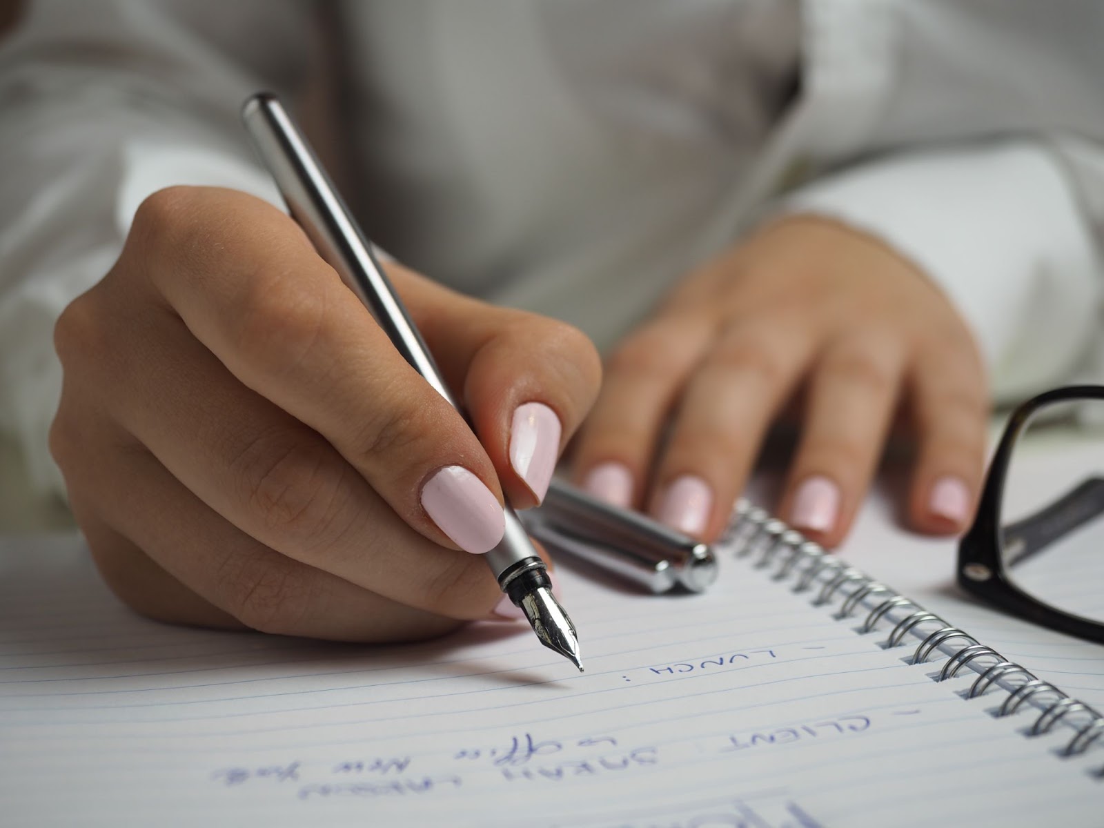 close up of a pair of hands writing in a notebook